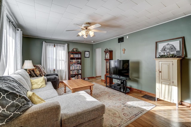 living room featuring light hardwood / wood-style floors, ceiling fan, and ornamental molding