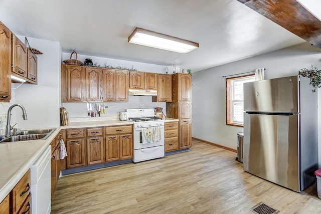 kitchen with sink, white appliances, and light wood-type flooring