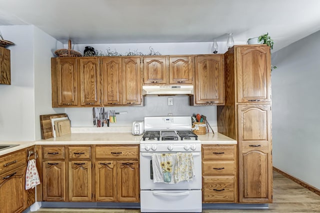 kitchen with white gas stove and light wood-type flooring