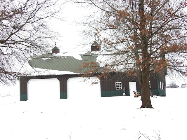 view of snowy exterior with a garage