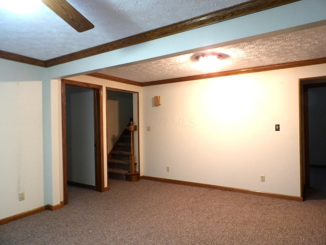 spare room with ceiling fan, carpet, ornamental molding, and a textured ceiling