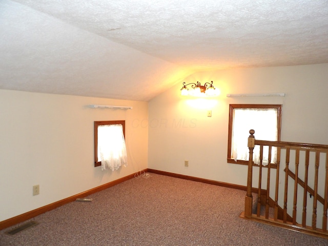 bonus room featuring carpet flooring, a textured ceiling, and lofted ceiling