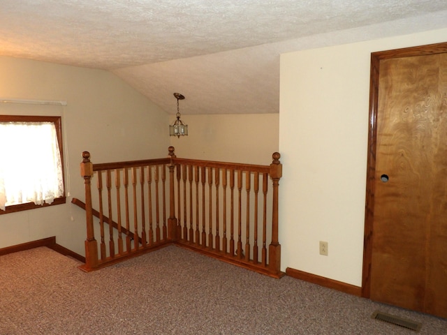 stairs with carpet, a textured ceiling, and lofted ceiling