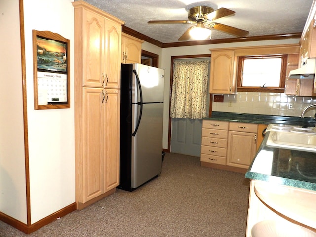 kitchen featuring sink, tasteful backsplash, a textured ceiling, ornamental molding, and stainless steel refrigerator