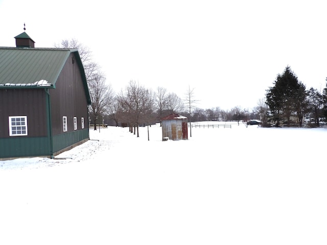 yard covered in snow featuring an outdoor structure