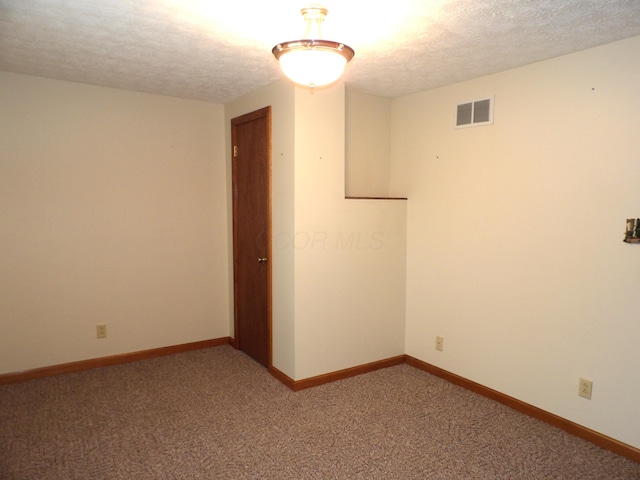 carpeted spare room with a textured ceiling