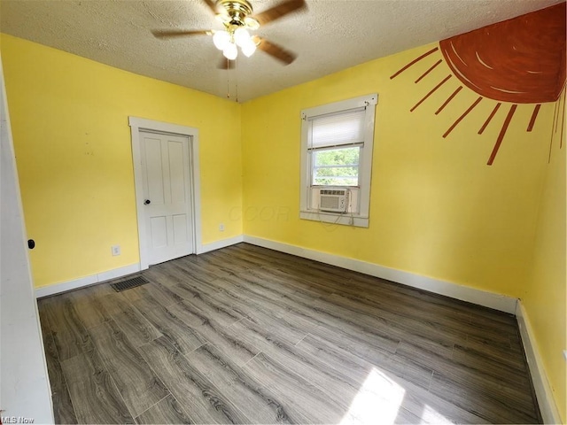 empty room with ceiling fan, hardwood / wood-style flooring, cooling unit, and a textured ceiling