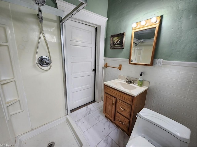 bathroom with toilet, a shower, and vanity