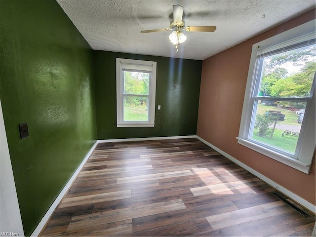 spare room featuring ceiling fan, a textured ceiling, and dark hardwood / wood-style flooring