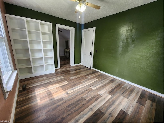 unfurnished bedroom with ceiling fan, a textured ceiling, and wood-type flooring