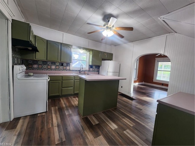 kitchen featuring green cabinets, sink, dark wood-type flooring, white appliances, and a center island