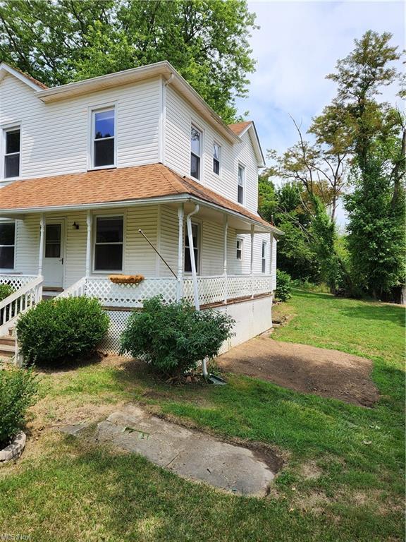 view of front of house with a front yard and a porch