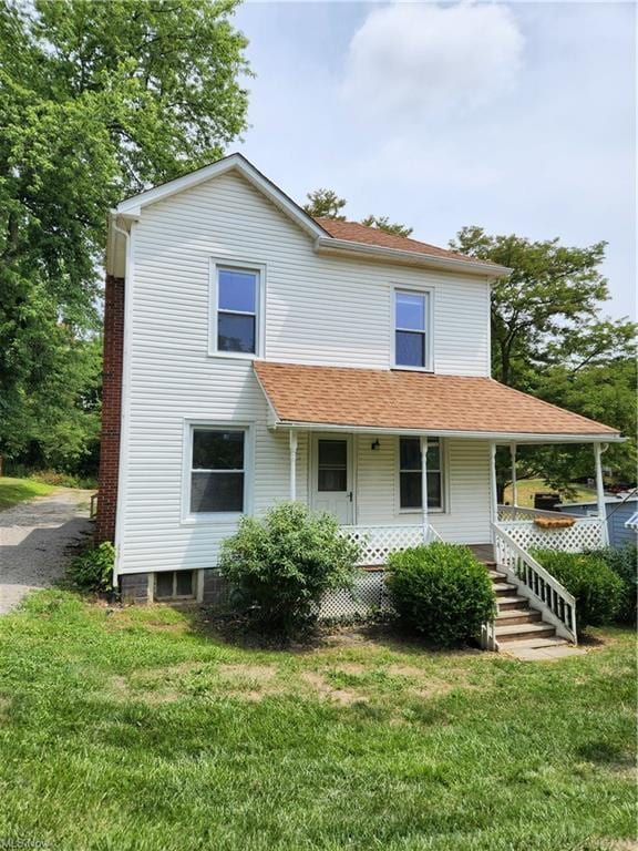 view of front of house with a front yard and covered porch