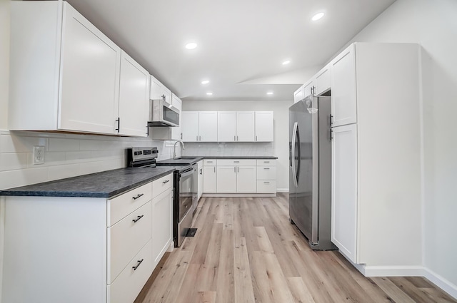 kitchen featuring sink, white cabinetry, tasteful backsplash, light hardwood / wood-style flooring, and stainless steel appliances