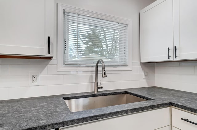 kitchen featuring sink, decorative backsplash, and white cabinets