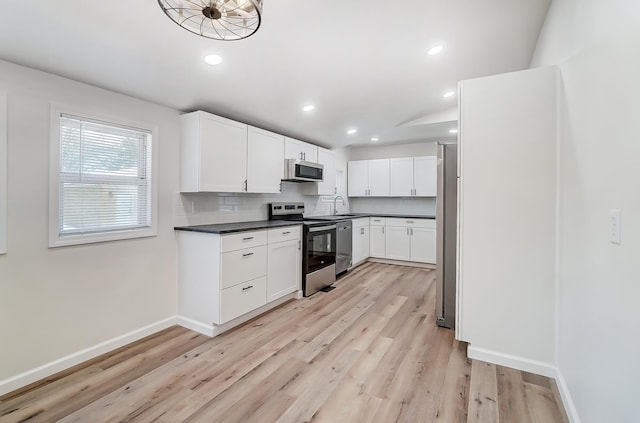 kitchen with sink, tasteful backsplash, stainless steel appliances, light hardwood / wood-style floors, and white cabinets