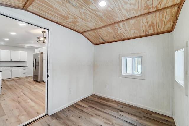 additional living space with vaulted ceiling, wooden ceiling, and light wood-type flooring