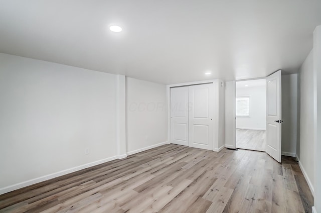 unfurnished bedroom featuring light hardwood / wood-style floors and a closet