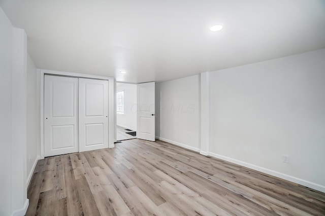 unfurnished bedroom with a closet and light wood-type flooring