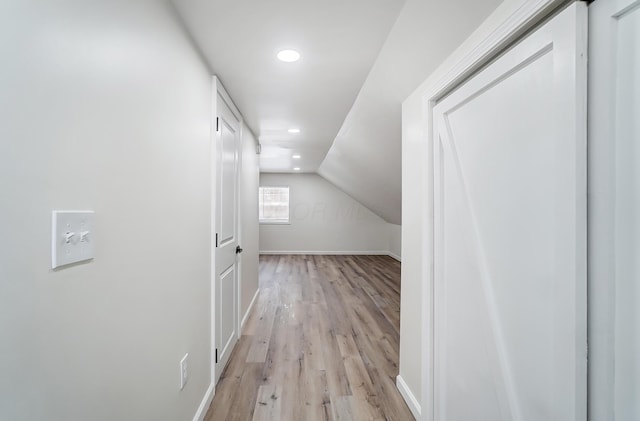 bonus room with vaulted ceiling and light hardwood / wood-style flooring