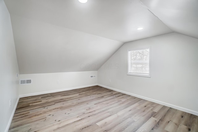 additional living space with lofted ceiling and light hardwood / wood-style floors