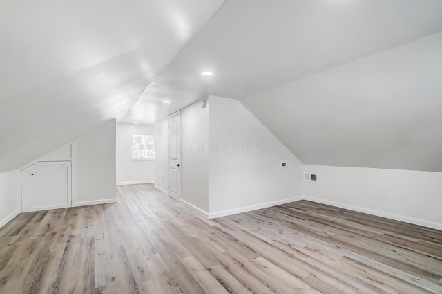 bonus room featuring light hardwood / wood-style flooring and vaulted ceiling