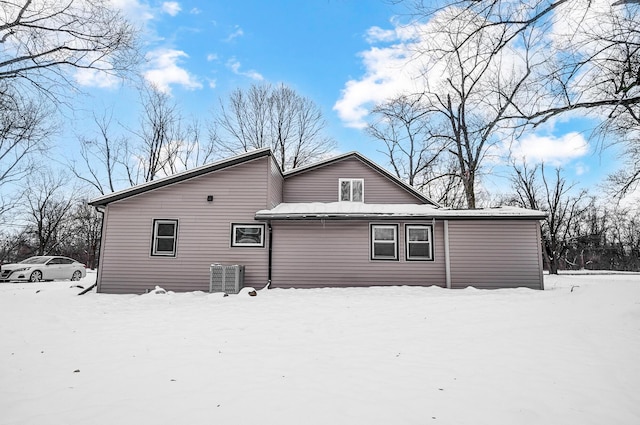 snow covered back of property with central AC unit