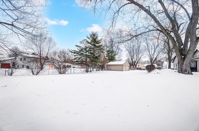 yard layered in snow featuring an outbuilding