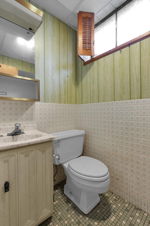 bathroom with toilet, vanity, and tile patterned flooring