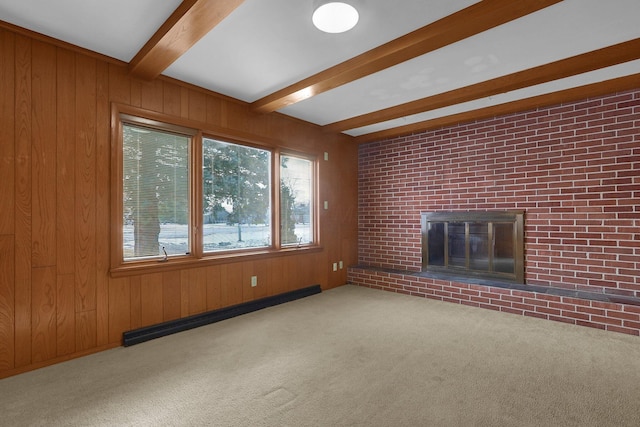 unfurnished living room with a baseboard radiator, light colored carpet, a fireplace, wood walls, and beamed ceiling