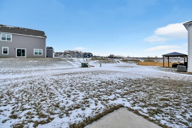 yard covered in snow featuring a gazebo and central AC unit