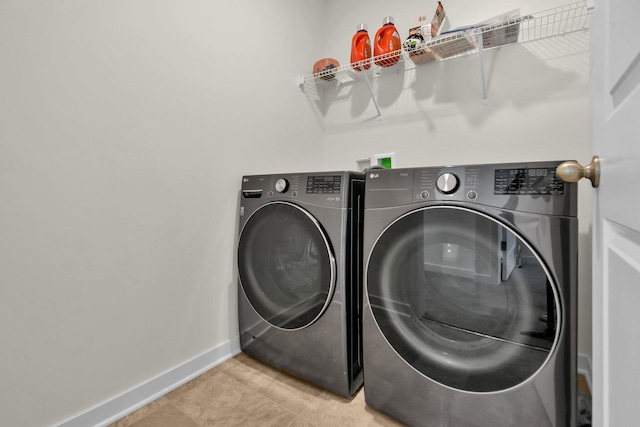 clothes washing area with tile patterned flooring and washer and dryer