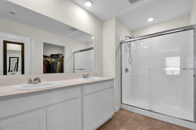 bathroom featuring a shower with shower door and vanity