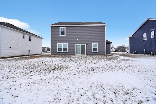 view of snow covered rear of property