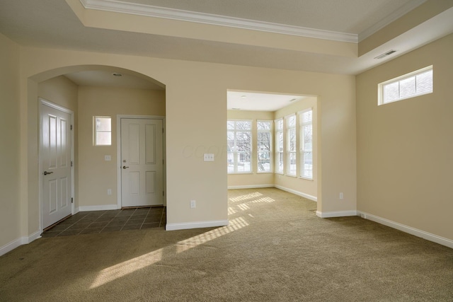 carpeted foyer entrance with a raised ceiling and ornamental molding