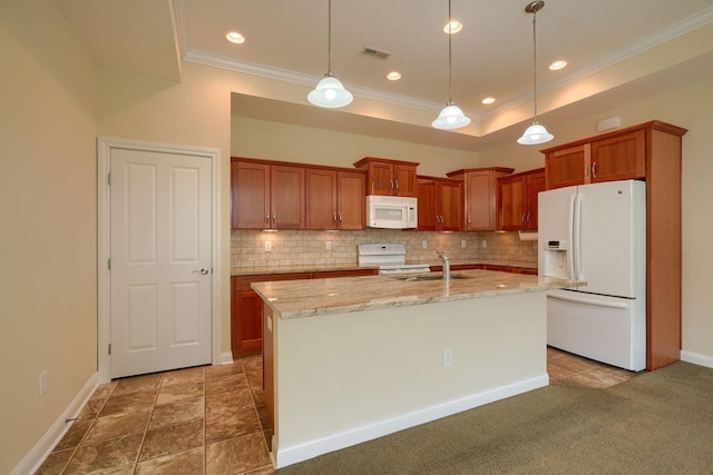 kitchen featuring white appliances, tasteful backsplash, sink, decorative light fixtures, and a center island with sink