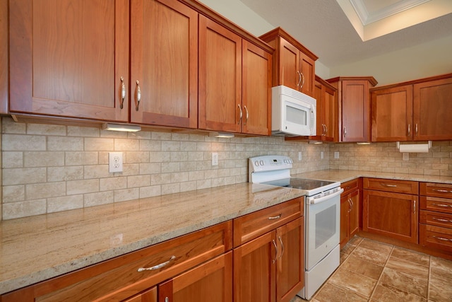 kitchen featuring light stone counters, white appliances, crown molding, and tasteful backsplash