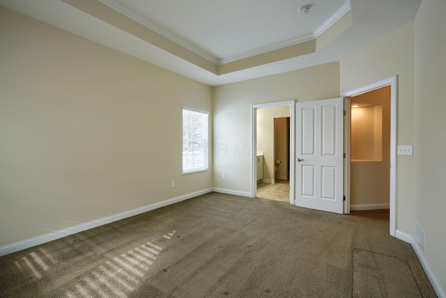 unfurnished bedroom featuring connected bathroom, light carpet, a raised ceiling, and crown molding