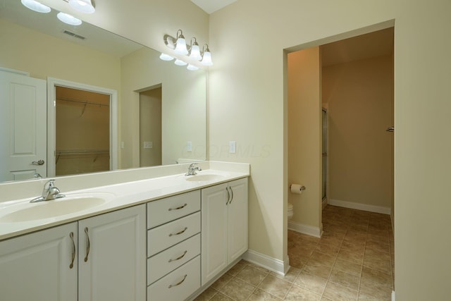 bathroom featuring a shower with door, toilet, and vanity