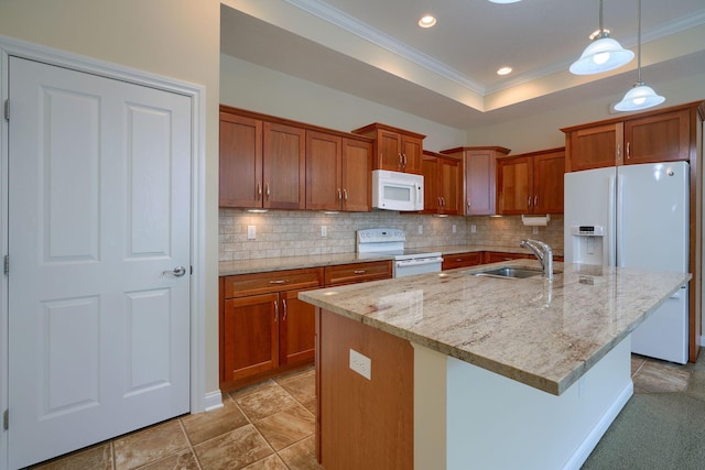 kitchen featuring sink, a center island with sink, white appliances, and decorative light fixtures