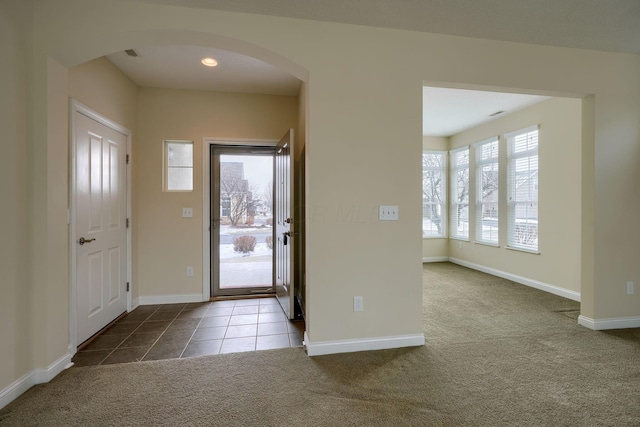 foyer featuring light carpet and plenty of natural light