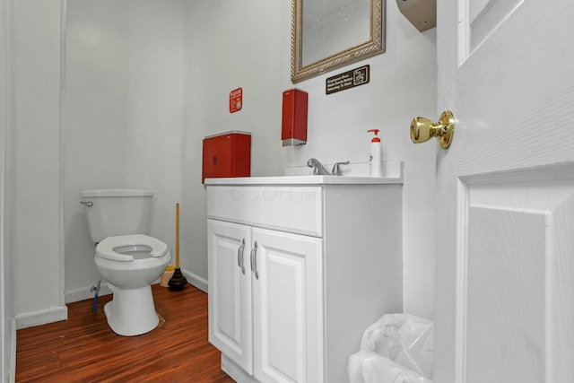 bathroom featuring wood-type flooring, toilet, and vanity