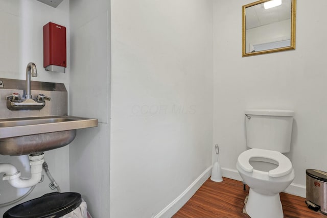 bathroom with sink, toilet, and hardwood / wood-style floors