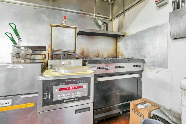 kitchen featuring dark tile patterned floors and stainless steel gas range oven