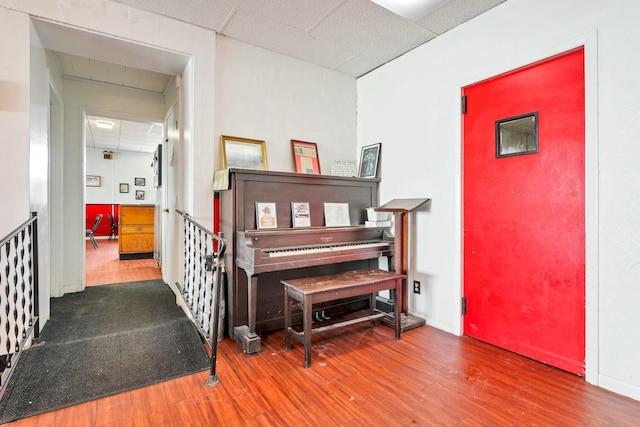 miscellaneous room with a paneled ceiling and hardwood / wood-style flooring