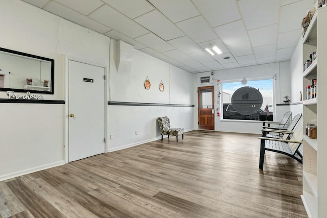 misc room featuring a paneled ceiling and hardwood / wood-style floors