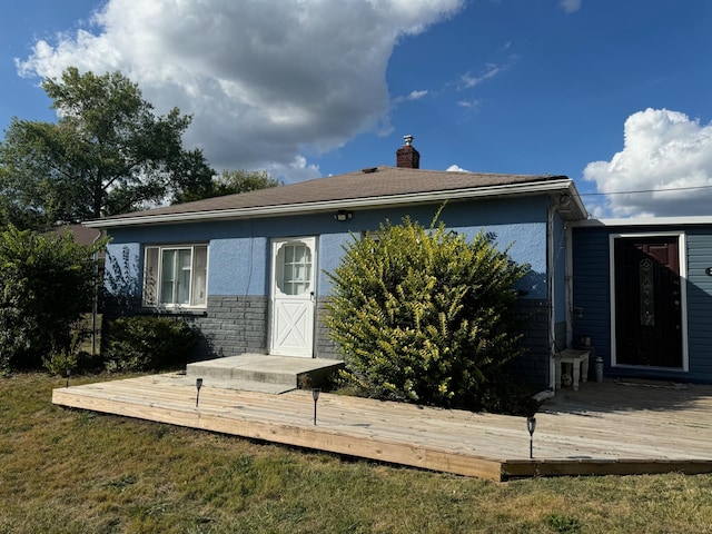 view of front of property featuring a front lawn and a deck