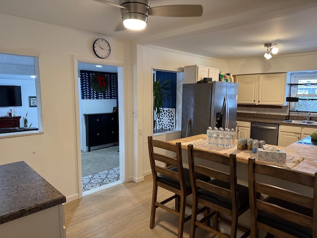 kitchen with ceiling fan, stainless steel appliances, sink, and light hardwood / wood-style flooring