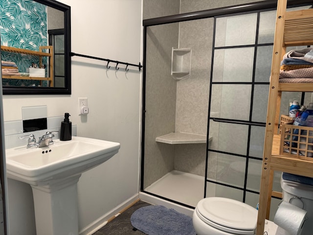 bathroom with sink, an enclosed shower, and toilet