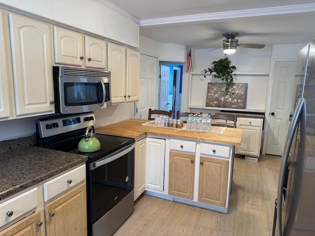 kitchen with butcher block counters, ceiling fan, kitchen peninsula, stainless steel appliances, and light hardwood / wood-style flooring